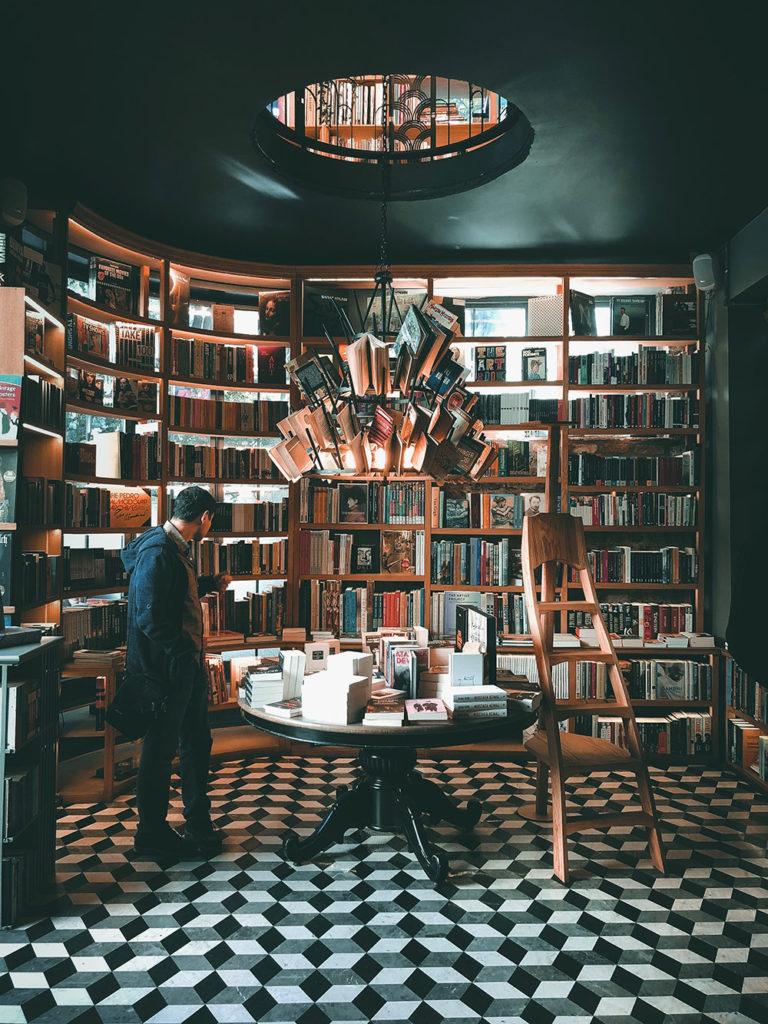 person browsing bookstore with book chandelier